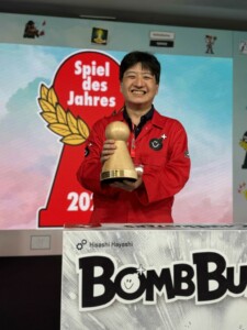 Hisashi Hayashi tenant le pion du Spiel des Jahres après la victoire !